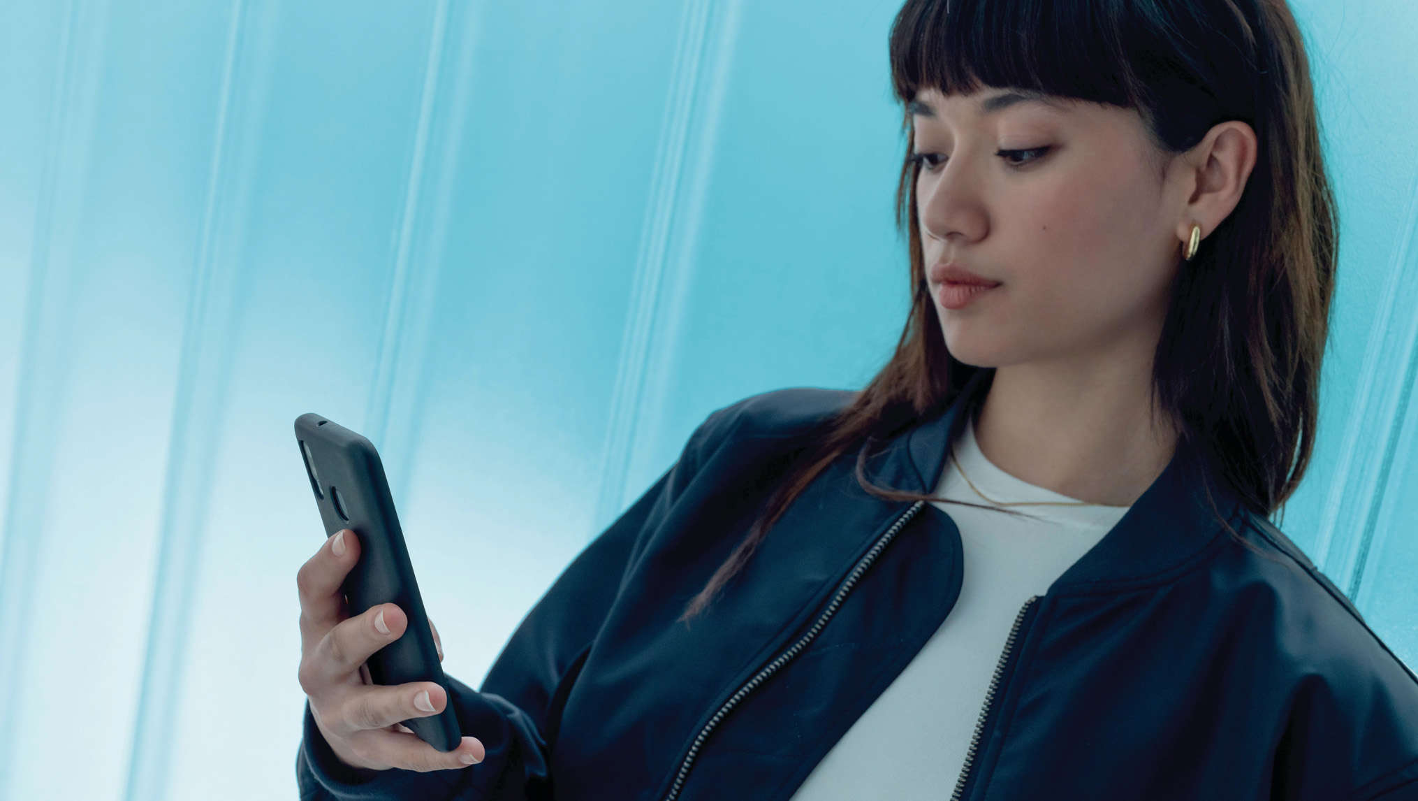 Дівчина дивиться на екран смартфону